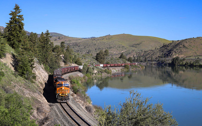 A BNSF Tier 4 locomotive leads a grain train along the Flathead River. A BNSF Tier 4 locomotive leads a grain train along the Flathead River.